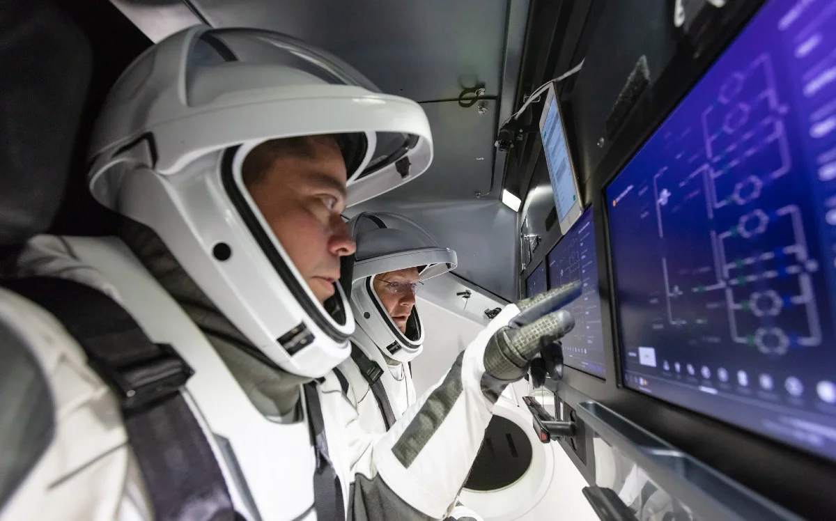 Astronautas a bordo de una cápsula Crew Dragon durante operaciones de control. La imagen ilustra el rol central de SpaceX en el transporte tripulado de la NASA hacia la Estación Espacial Internacional